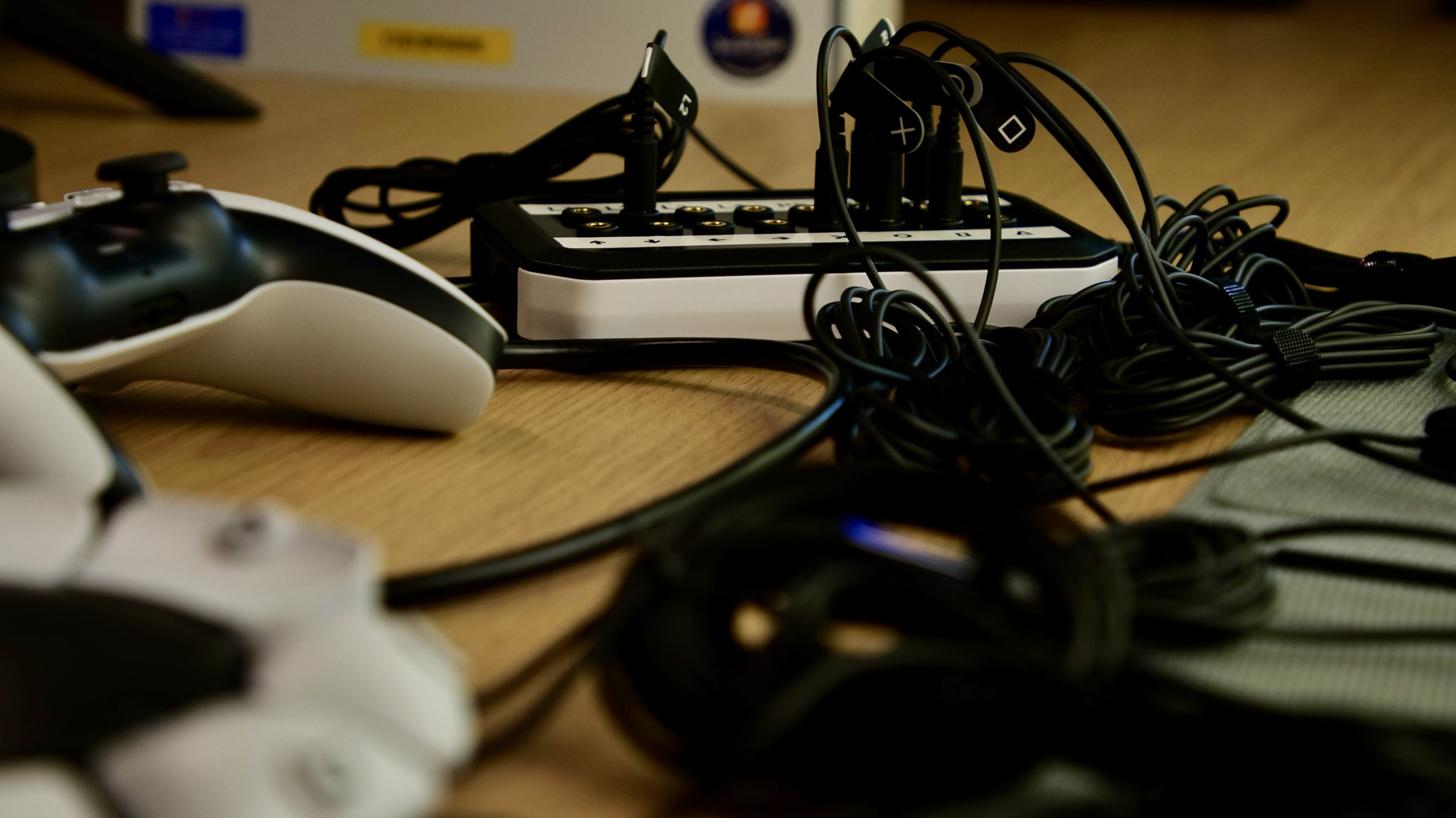 The 19-switch DualSense interface is shown in focus amongst cables from switches connected to it and an Access controller which is out of focus in the foreground.