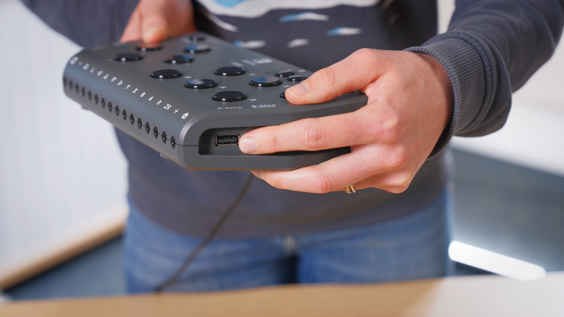 A Hori Flex controller being held with a finger poiting to the Right Stick USB slot.