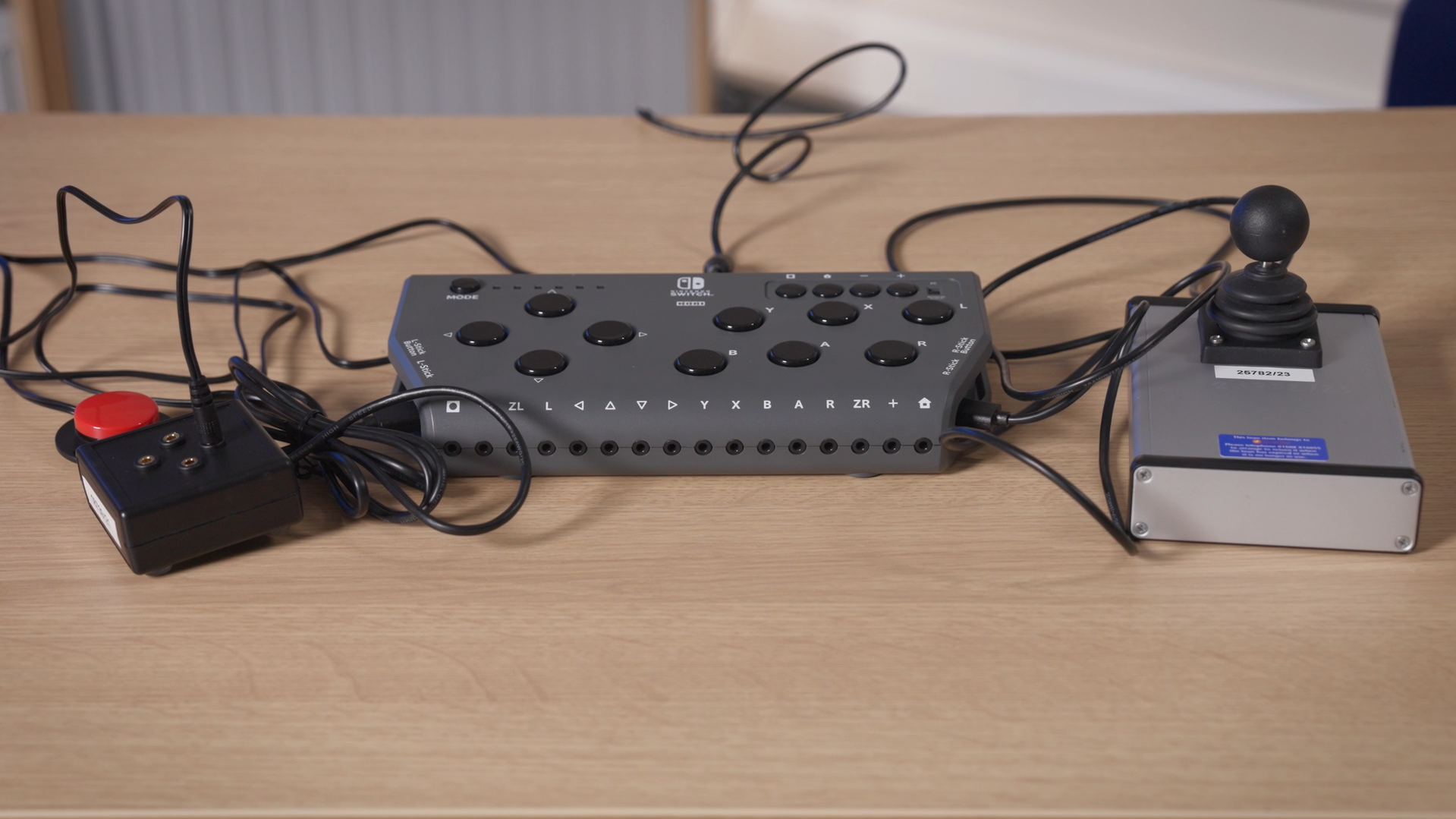 A photo of the Hori Flex with a ZikZak joystick connected to the right USB port and a Switch to Joystick Box connected to the left USB port which has an AbleNet Specs switch connected into the Up 3.5mm switch port.