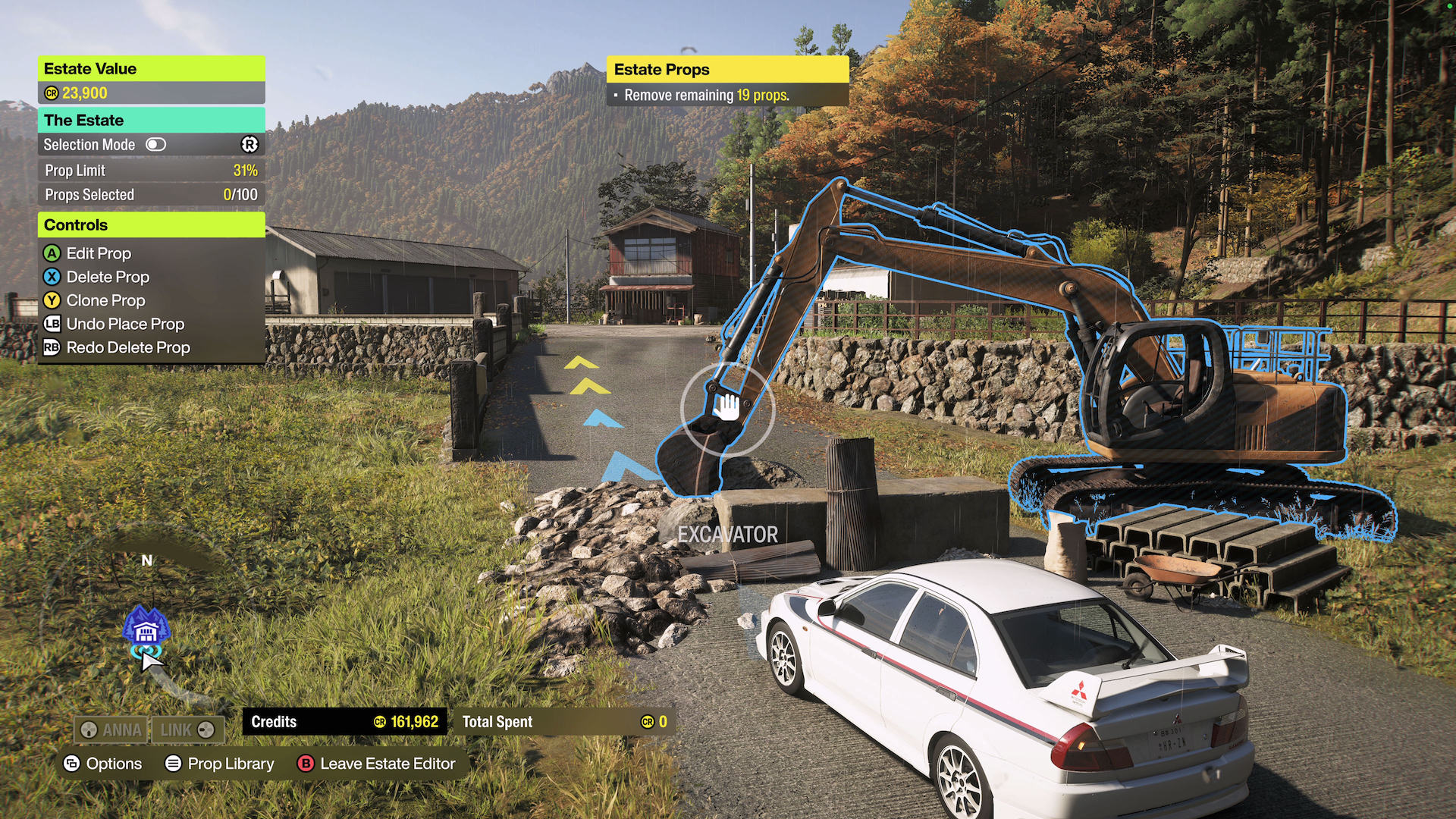 Screnshot showing a vehicle parked infront of an excavator and a pile of rubble blcking the road. A cursor in the centre of the screen is over the excavator with control options shown for A to Edit Pro, X to Delete Prop and Y to Clone Prop.