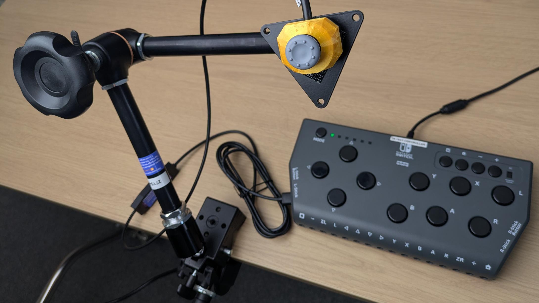 Photo of a J3 Compact Very Light Force JN Mini Joystick, on a maunting plate on a Manfrotto Variable Friction Mounting Arm with a Hori Flex interface in the background.